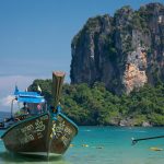 a boat in the water with Railay Beach in the background